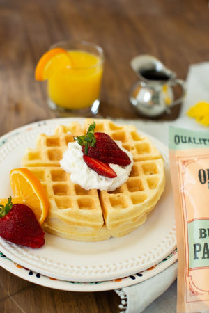 
                  
                    Load image into Gallery viewer, Perfect waffles topped with butter and sliced strawberries. Glass of orange juice is pictured as well.
                  
                