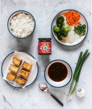 
                  
                    Load image into Gallery viewer, Jenkins Jellies is your new pantry staple! Shown here is the Passion Fruit hot pepper jam that is used in a sweet and spicy sauce for this fried tofu dinner. Also pictured is a bowl of rice and veggies consisting of broccoli, carrots, garlic and green onions.
                  
                