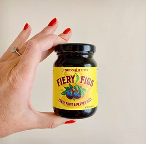 
                  
                    Load image into Gallery viewer, 5 oz. jar of Fiery Figs pepper jelly held in a persons hand, showing the size relationship. These 5 oz jars of the fresh fig fruit and hot chill pepper jelly are perfect for summer picnics and camping trips.
                  
                