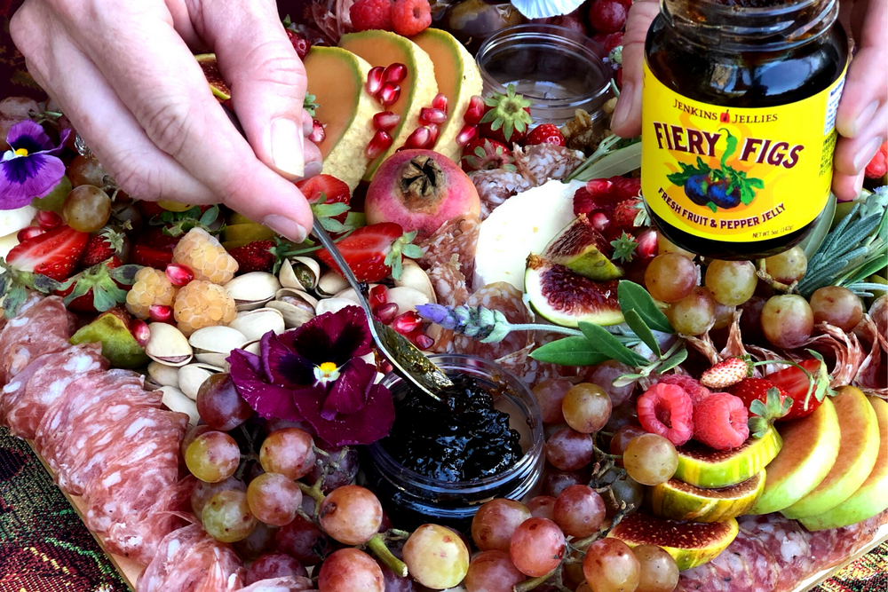 
                  
                    Load image into Gallery viewer, A beautiful charcuterie spread of fresh fruits like raspberries, grapes, melon, pomegranate seeds. Also a display of Pistachio nuts and salami, crackers, cheese topped of with a container of Jenkins Jellies Firey Figs pepper jelly. Made with fresh figs and seven hot and sweet chillis--this 5 oz. jar of hot pepper jam is a perfect appetizer on every party table.
                  
                